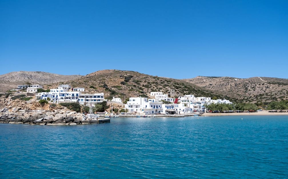 Sikinos greek island port, white buildings and blue sky background.