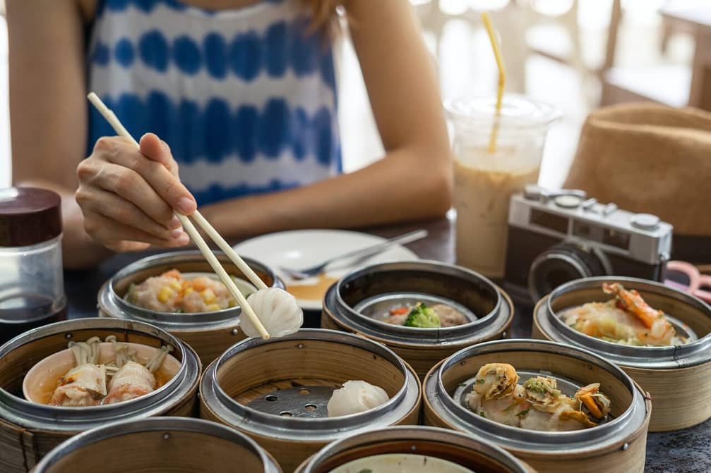 Young woman traveler eating local food(dim sum) at phuket, Thailand