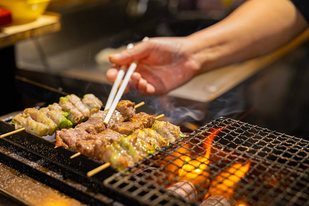 Meat on barbecue grill at food market in Kyoto Japan