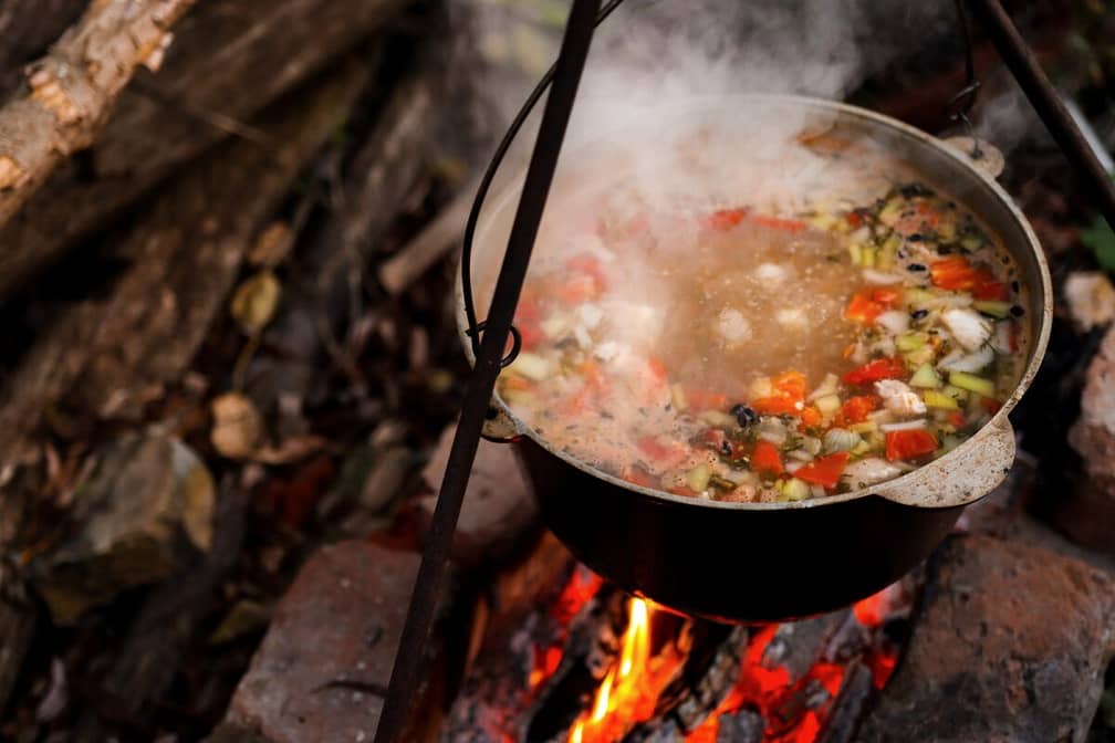 A pot of hot food in the forest, outdoor recreation at night. Hiking, travel and wilderness