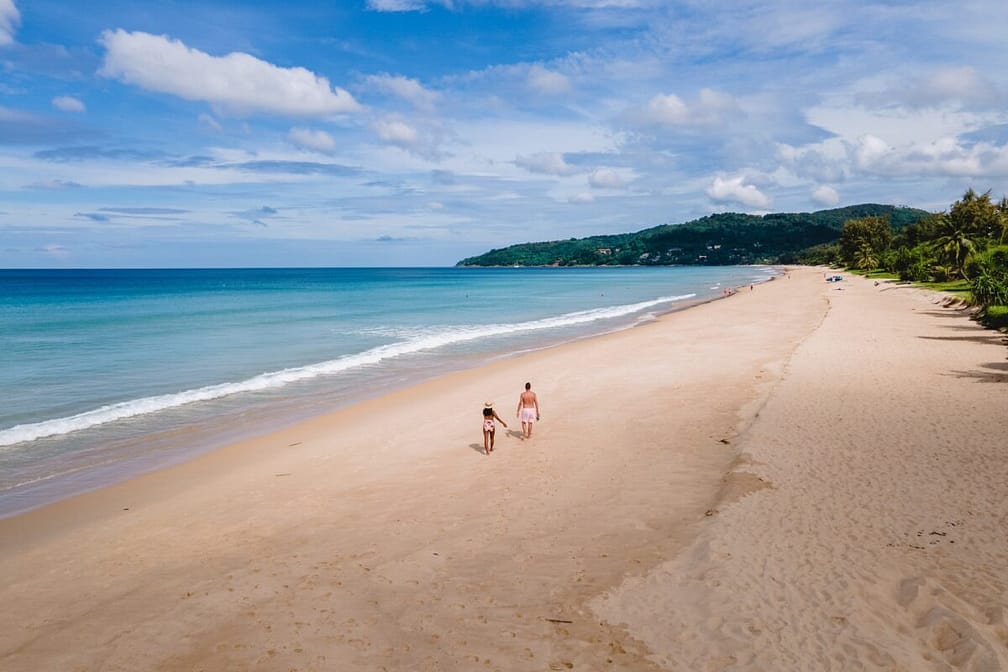 Drone view at couple walking on the beach of Karon Phuket Thailand