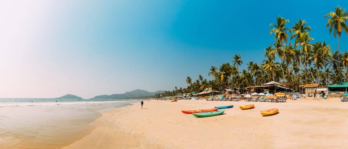 Canacona, Goa, India. Canoe Kayak For Rent Parked On Famous Palolem Beach On Background Tall Palm