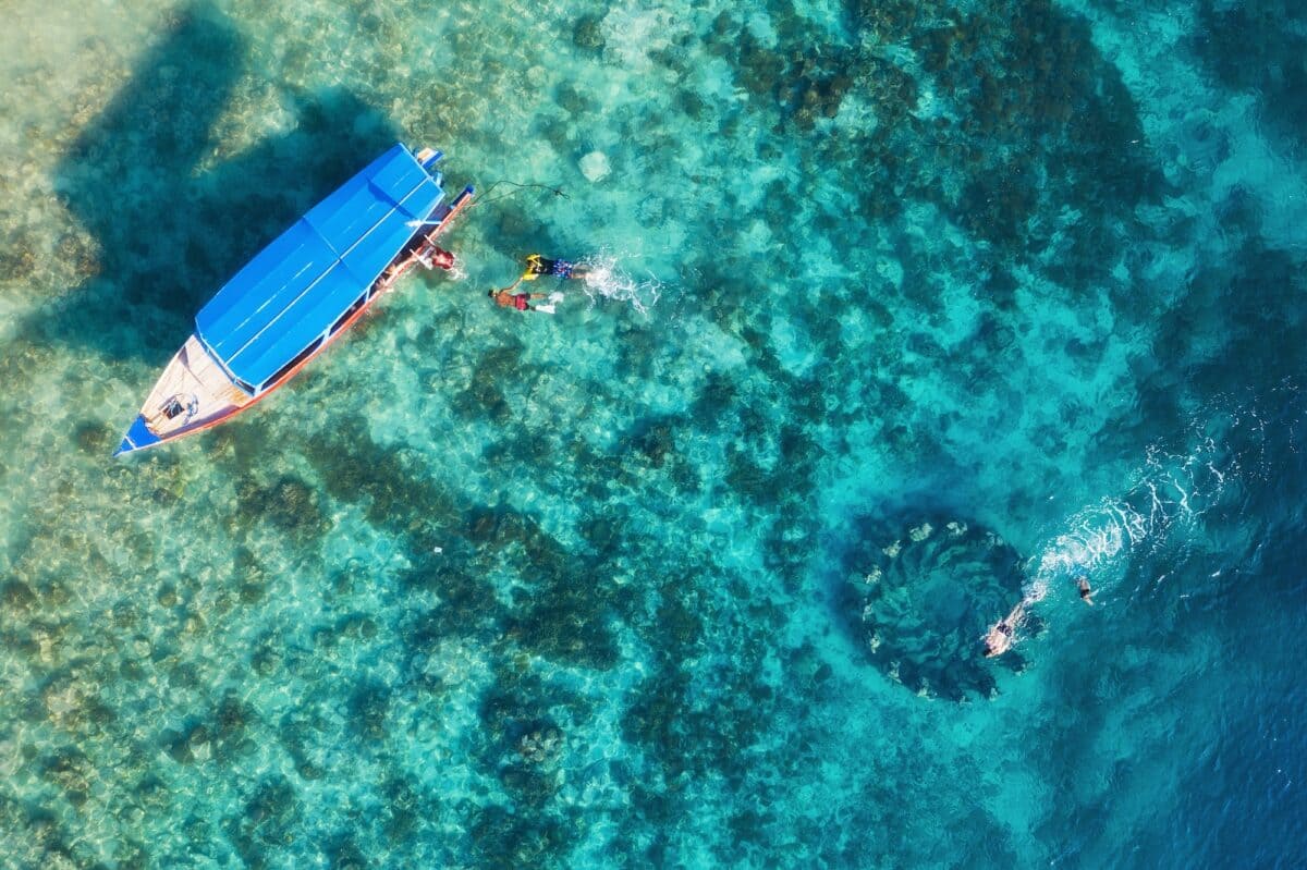 The people are snorkeling near the famous place on Gili Meno Island, Indonesia. Aerial view.