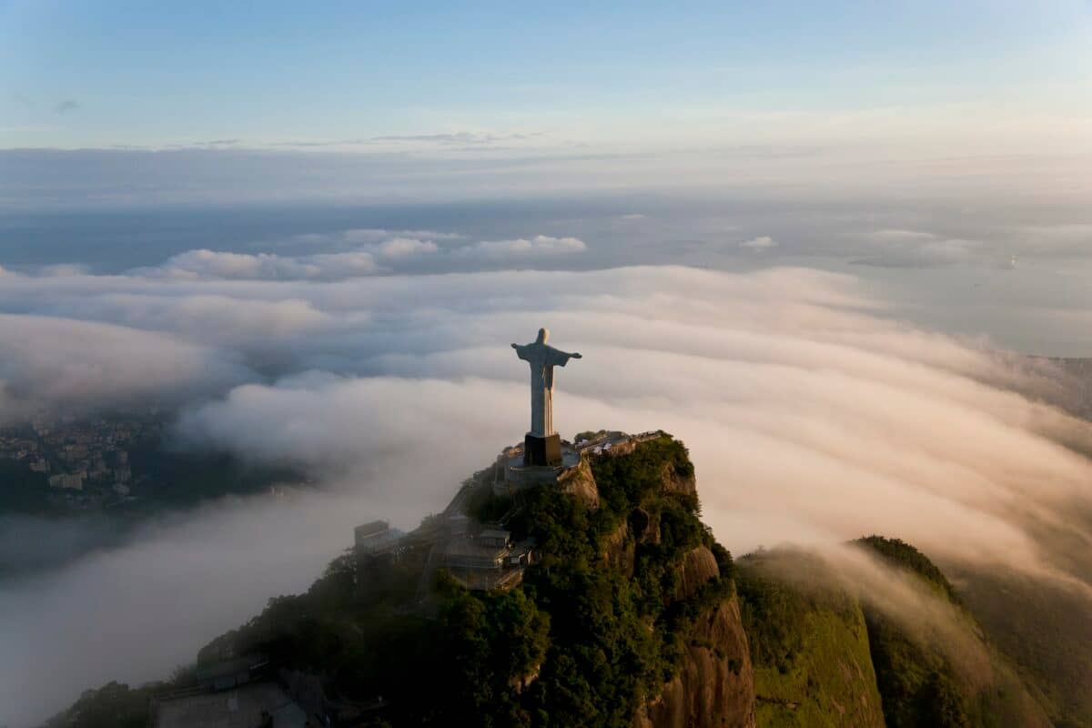 High angle view of colossal Christ Redeemer statue surrounded by clouds, Corcovado, Rio de Janeiro,
