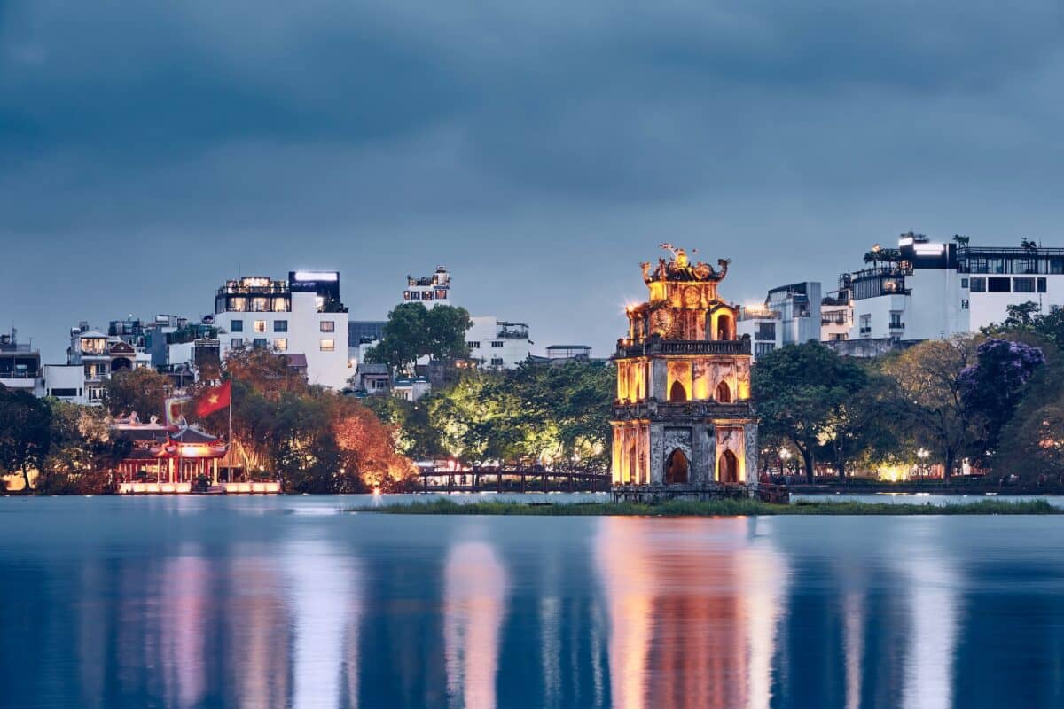Skyline of Hanoi at dusk. Turtle Tower on Hoan Kiem Lake in old quarter.