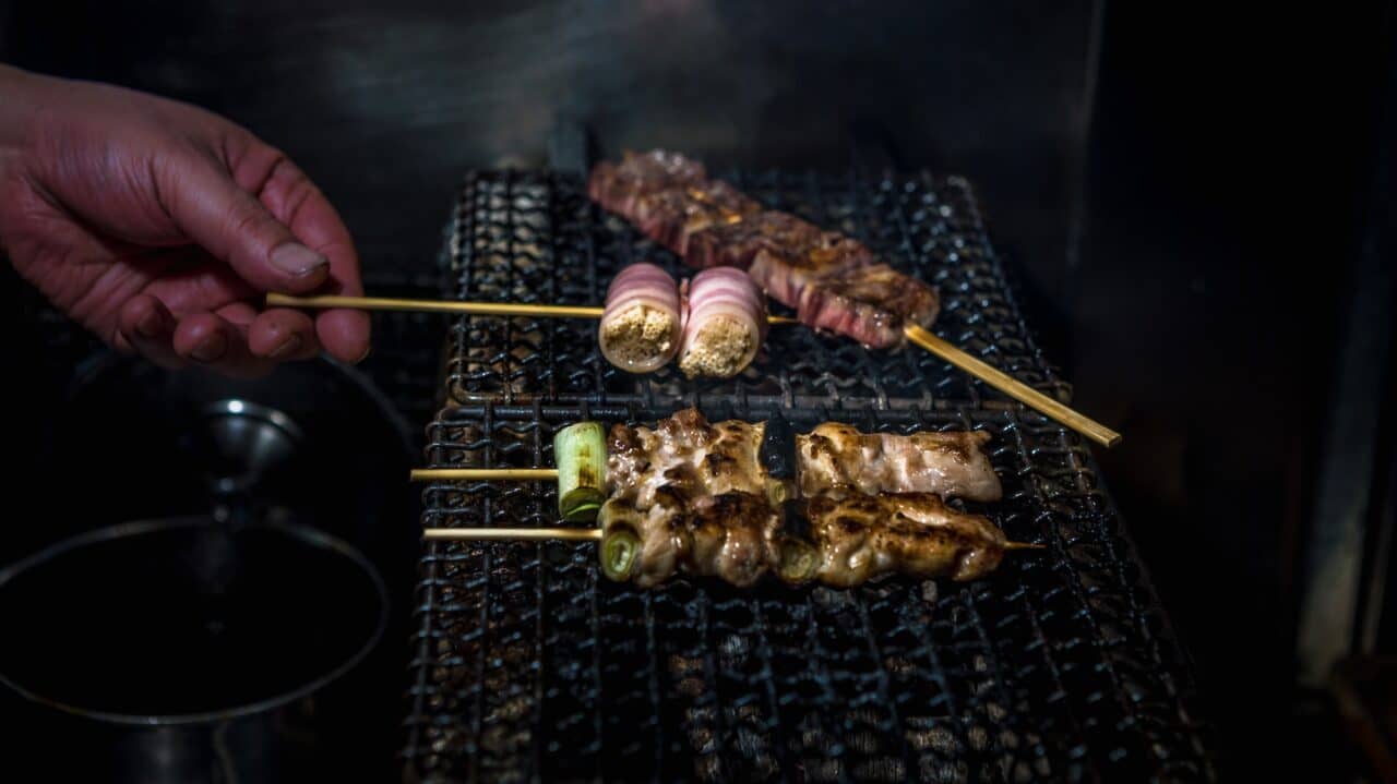 Chef cooking inside izakaya Japanese bar in Tokyo. Japan food