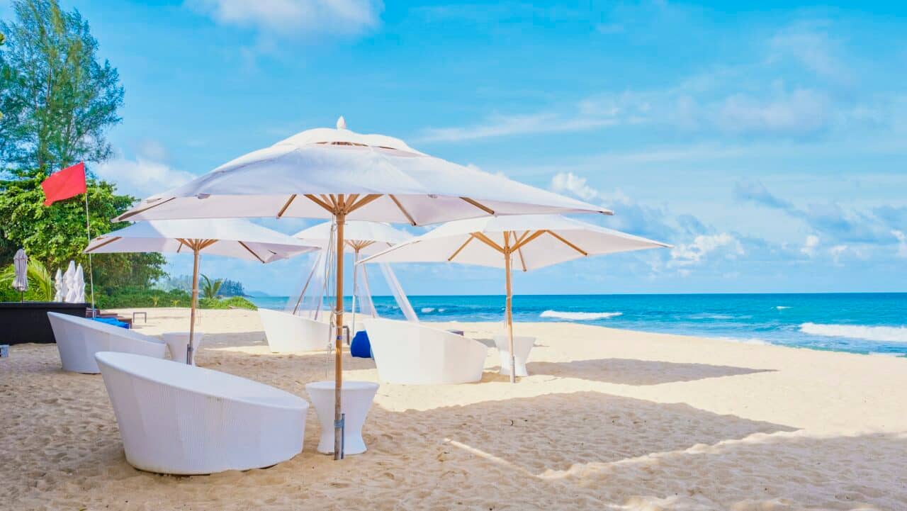 Luxury beach beds and umbrella on the beach, with chairs and white umbrella on the beach in Phuket