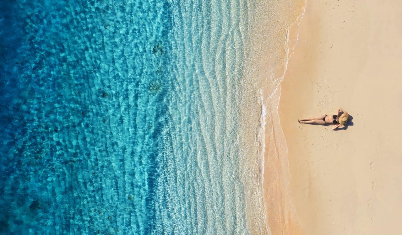 A girl resting on the beach. The view from the air. Bali island, Indonesia.