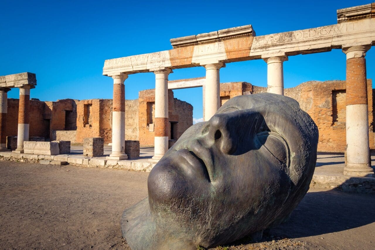 Scenic view of ruins and bronze statue in ancient Pompeii city