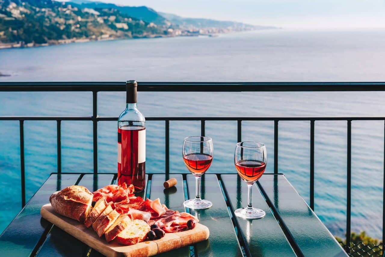 Two glasses of wine and italian snacks with amazing view at sunset in Italy.