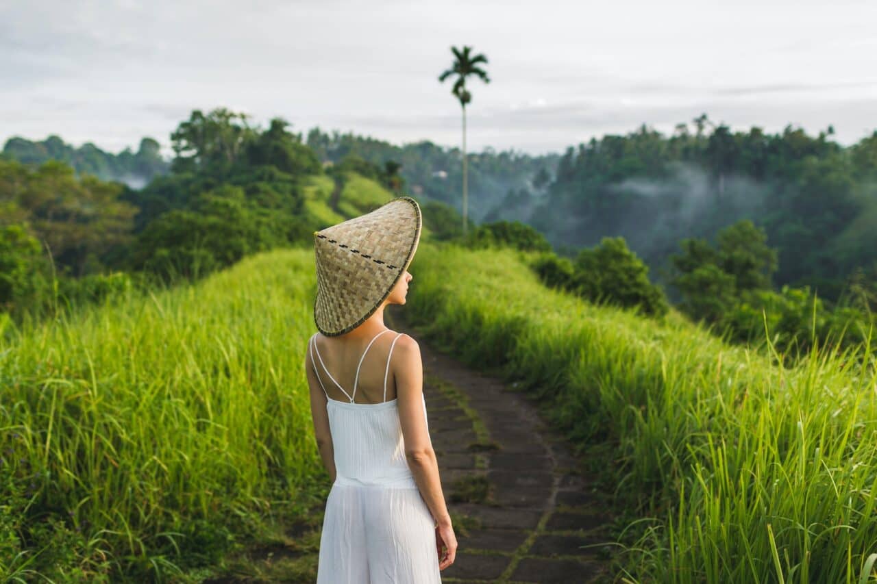 Young beautiful woman walking on Campuhan Ridge way of artists, in Bali, Ubud