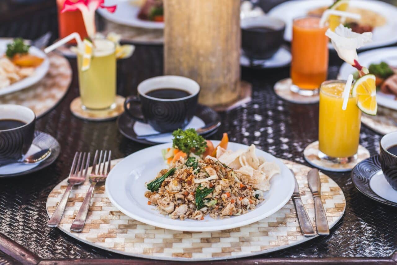 Traditional indonesian breakfast nasi goreng with bali kopi on white plate and silver cutlery