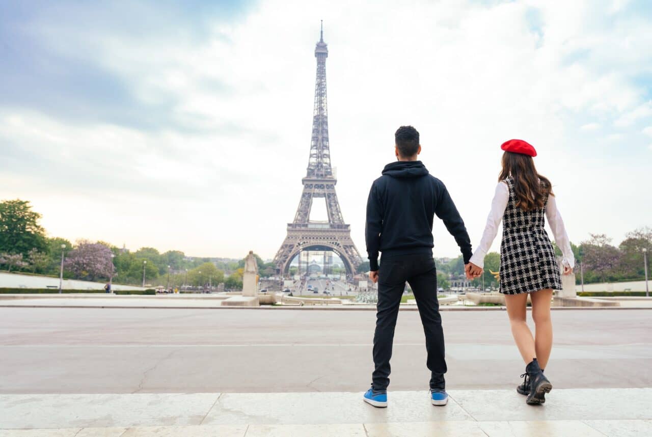 cheerful happy couple in love visiting Paris city centre and Eiffel Tower