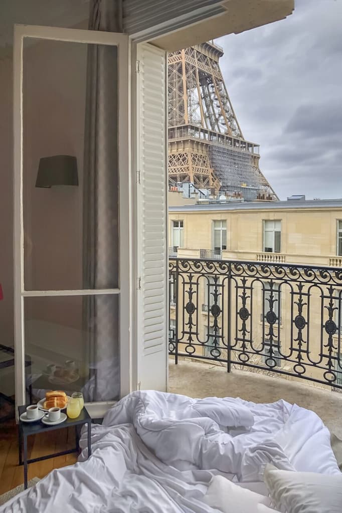 Window view of the Eiffel Tower with breakfast in a bed